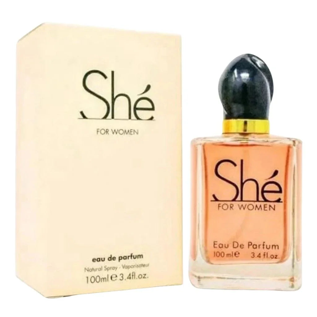 She 100ml Eau de Parfum in a clear rectangular bottle with an elegant black cap next to its cream-colored retail box.