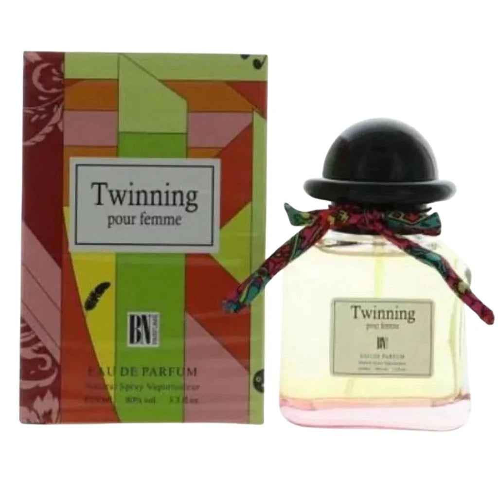 Twinning 100ml Eau de Parfum clear glass bottle with a black cap and colorful neck scarf, standing next to its vibrant green and orange patterned box.